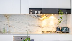 Eine moderne Küche mit Marmor-Spritzschutz, einem eingebauten Herd und einem Toaster.