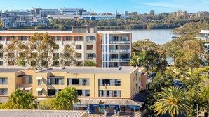A modern building with multiple floors, large windows, and balconies. - Kozyguru | Wentworth Point | 2B Apt+Free Parking (Wentworth Point)