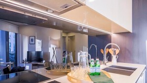 Una cocina moderna con una isla central, horno empotrado y un lavamanos de acero inoxidable.