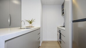 Una cocina moderna con una isla central, electrodomésticos de acero inoxidable y una planta en maceta.