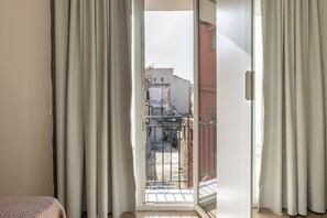 A room with a sliding glass door leading to a balcony with a metal railing. - Crispi Suite in Palermo by Wonderful Italy (Palermo)