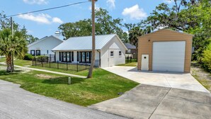 A residential property with a garage, a covered porch, and a well-maintained lawn. - Charming 2-bedroom apartment in lovely DeBary with AC, WiFi (DeBary)