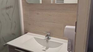 A bathroom with a white sink, a mirror, and a towel rack.