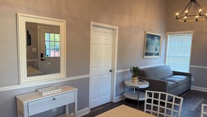 A dining area with a table, chairs, a console table, a bench, and a round side table with a plant. - The Charming Villa C, located by the pool, is an ideal getaway. (Moultrie)