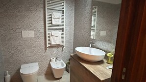Un baño con inodoro, bidé y lavamanos.