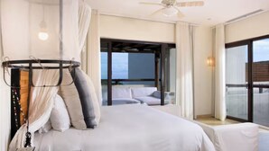 Un dormitorio con cama, ventilador de techo y vista al exterior.