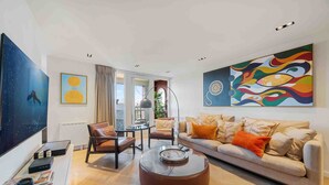 A modern living room with a sofa, coffee table, and artwork on the walls.