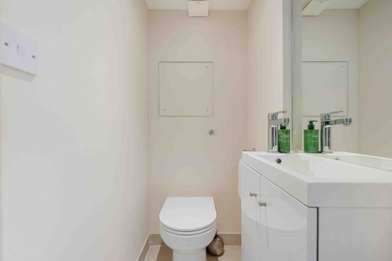 Ein Badezimmer mit Toilette, Waschbecken und Spiegel.