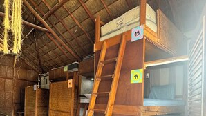 A rustic cabin with wooden bunk beds, numbered tags, and a ladder. - hostal casa holbox (Isla Holbox)
