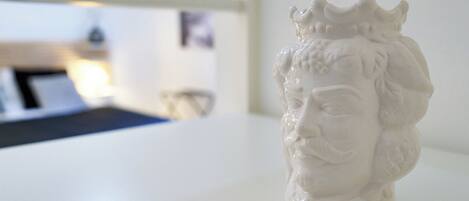 Une sculpture en buste blanche, posée sur une surface blanche.