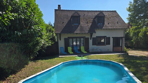 A swimming pool with a house in the background. - Gîte du Puits Tournant (Poilly-lez-Gien)
