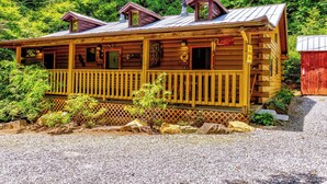 A wooden cabin with a porch, a small deck, and a chimney. - Indian Creek Cabin at Ponderosa (Cherokee)