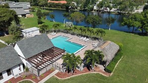 Una propiedad residencial con piscina, un porche cubierto y vistas al lago.