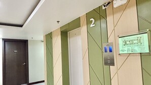 A hallway with a tiled floor, a door, and a wall-mounted emergency evacuation diagram.