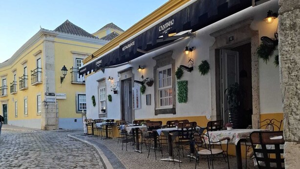 A cobblestone street with outdoor seating at a restaurant named 'CANTINHO'. - Casa Laranjeira in the historic city (Faro)