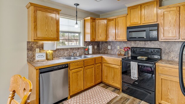 A kitchen with wooden cabinets, a dishwasher, a microwave, and a stove. - Charming house minutes from everything in Monroe/West Monroe! 5-Star hosts! (West Monroe)