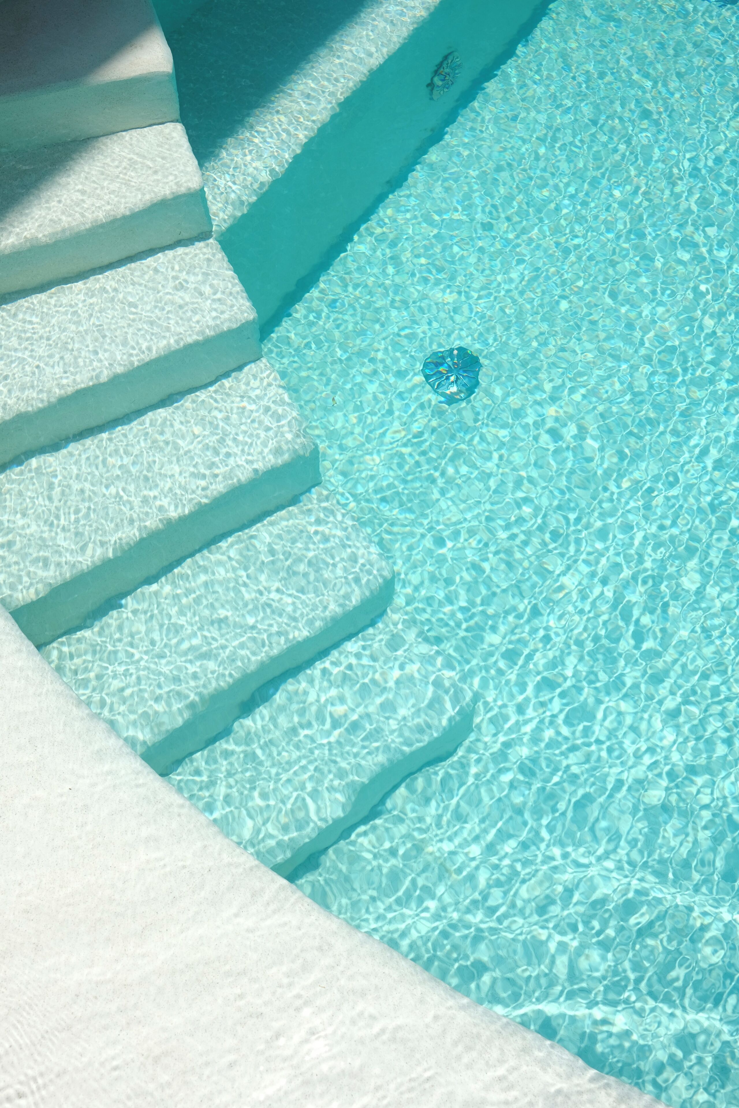A clear blue pool with steps leading into it.
