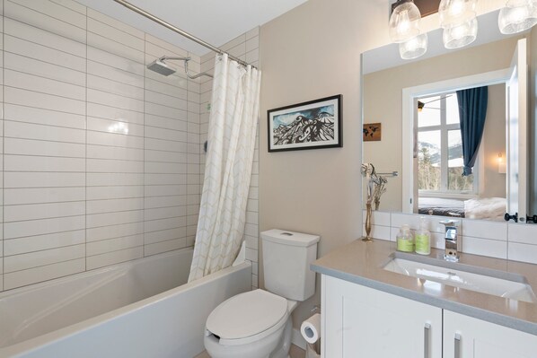 A modern bathroom with a bathtub, toilet, and sink. - Amazing Views, 10 Min to Downtown Canmore (Canmore)