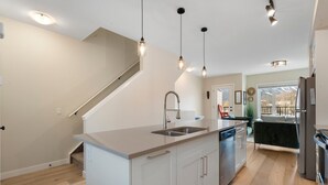 A modern kitchen with a central island, stainless steel appliances, and pendant lighting.