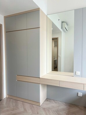 Une pièce dotée d’une armoire intégrée, d’un miroir et d’un interrupteur sur le mur.