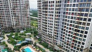 A high-rise residential building with a swimming pool complex, including a main pool and a smaller pool, surrounded by greenery and shaded areas. - Rose Vinhomes (Ho Chi Minh City)