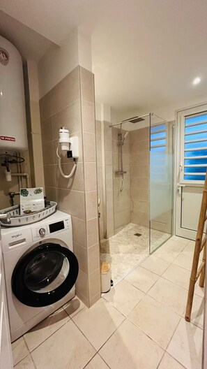 A modern bathroom with a washing machine, a glass shower enclosure, and a toilet. - JUST A STONE'S THROW FROM THE BEACH (Sainte-Luce)