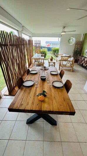 A dining area with a wooden table set for six, surrounded by chairs. - JUST A STONE'S THROW FROM THE BEACH (Sainte-Luce)