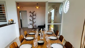 A dining area with a large wooden table set for six, surrounded by chairs. - SAINTE LUCE A STONE'S THROW FROM THE BEACH (Sainte-Luce)
