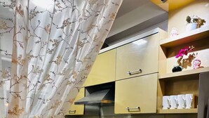 Una cocina con armarios amarillo claro, una estufa negra y una encimera blanca.