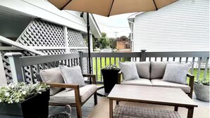 A patio with a sofa, chair, and table under a canopy. - The Driftwood, Saint Andrews (St. Andrews)