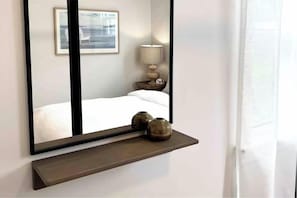 2 habitaciones, escritorio y tabla de planchar con plancha