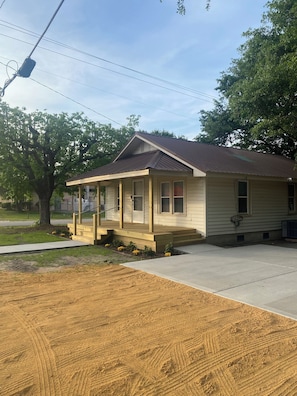 A small single-story house with a porch, a number '201' on the front, and a clear sky. - Charming 2-bedroom house with AC, WiFi in the heart of Pembroke (Pembroke)
