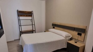 A bedroom with a bed, a nightstand, a wooden ladder, and a ceiling light. - PORTOCEL I (Marín)