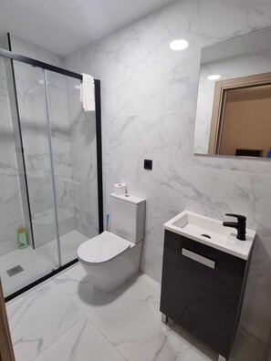 Chuveiro, toalhas de banho, sabonete, papel higiênico