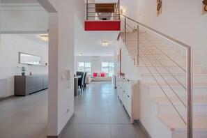 Een modern interieur met een trap, een eethoek en een keuken.