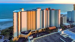 Un grand hôtel à plusieurs étages, doté d’un parking et offrant une vue sur l’océan.