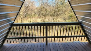 A wooden deck with a railing, leading to a view of trees and a clear sky. - Cedar Grove Rental A-frame (Clarksville)