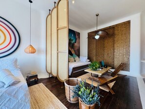 Een moderne woonkamer met een bank, een eettafel en een groot schilderij aan de muur.