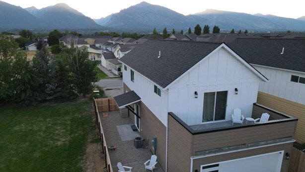 A residential area with houses, a backyard with a patio, and a mountain backdrop. - New 3BR w/ Garage, 1 Mile from Downtown (Hamilton)