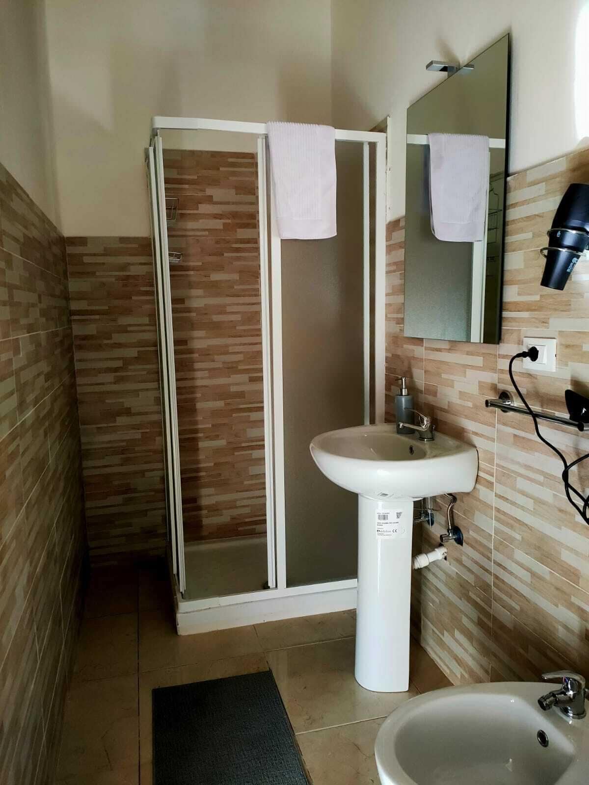 A bathroom with a shower, sink, and mirror.