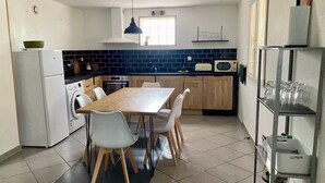 A compact kitchen with a dining table, chairs, a washing machine, a microwave, and a sink. - Mountain views with Heated pool and optional Jacuzzi. South of France (Olargues)