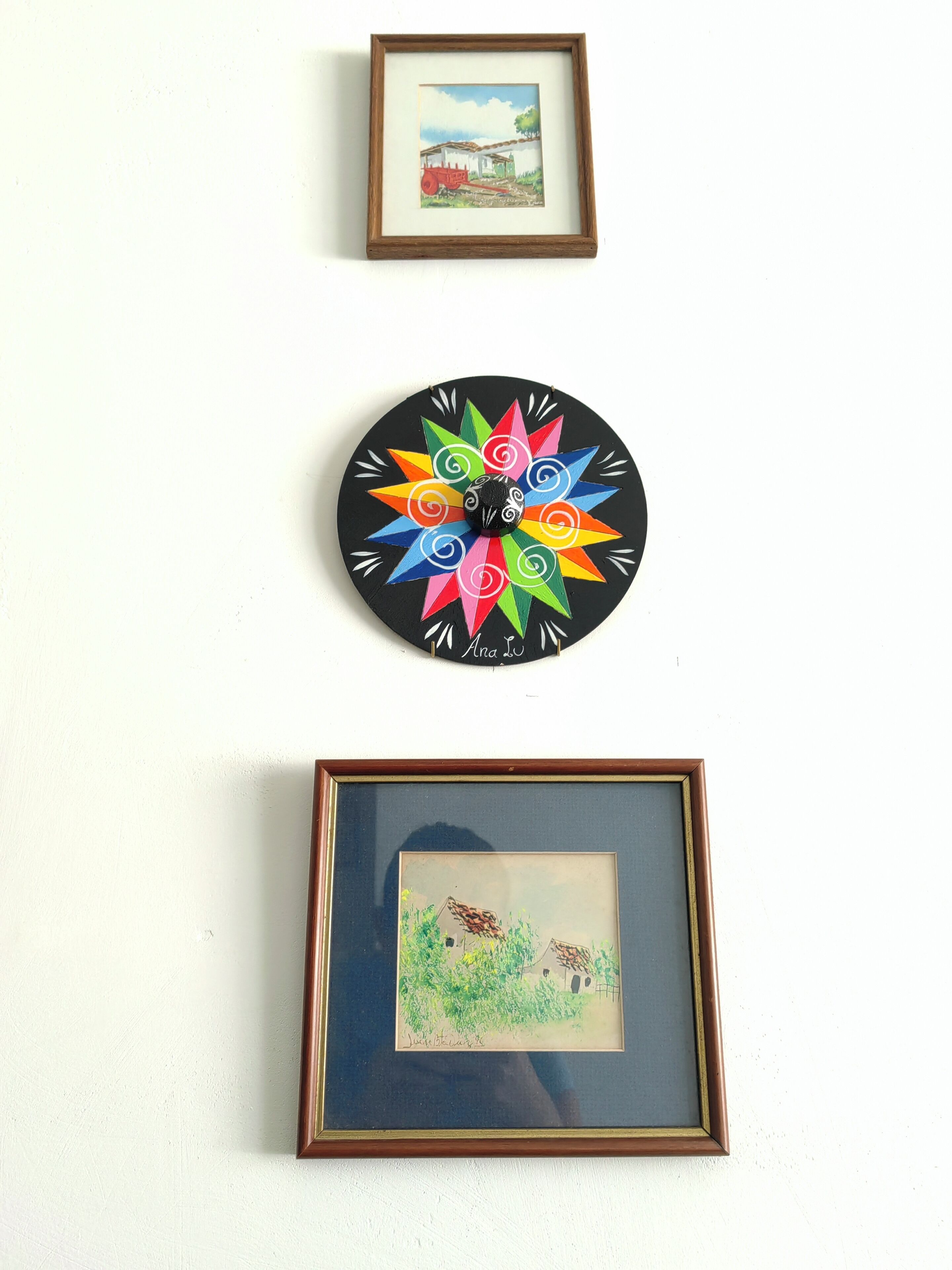 Three framed artworks on a wall.
