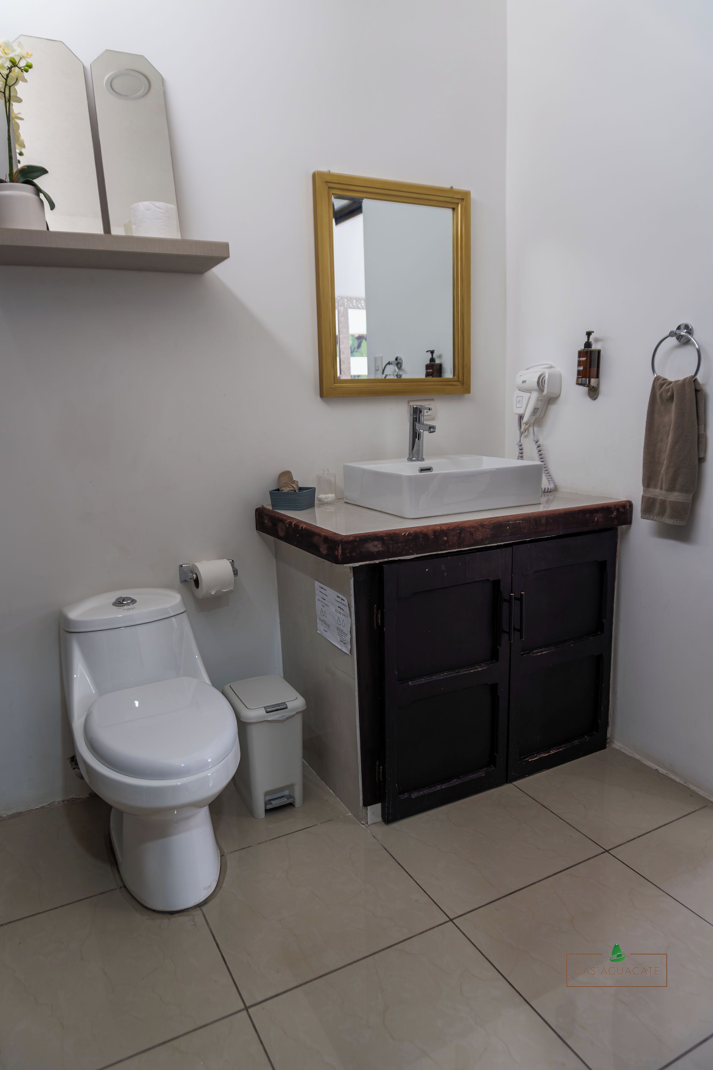 A bathroom with a toilet, sink, and mirror.
