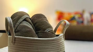 A basket with shoes on a bed.