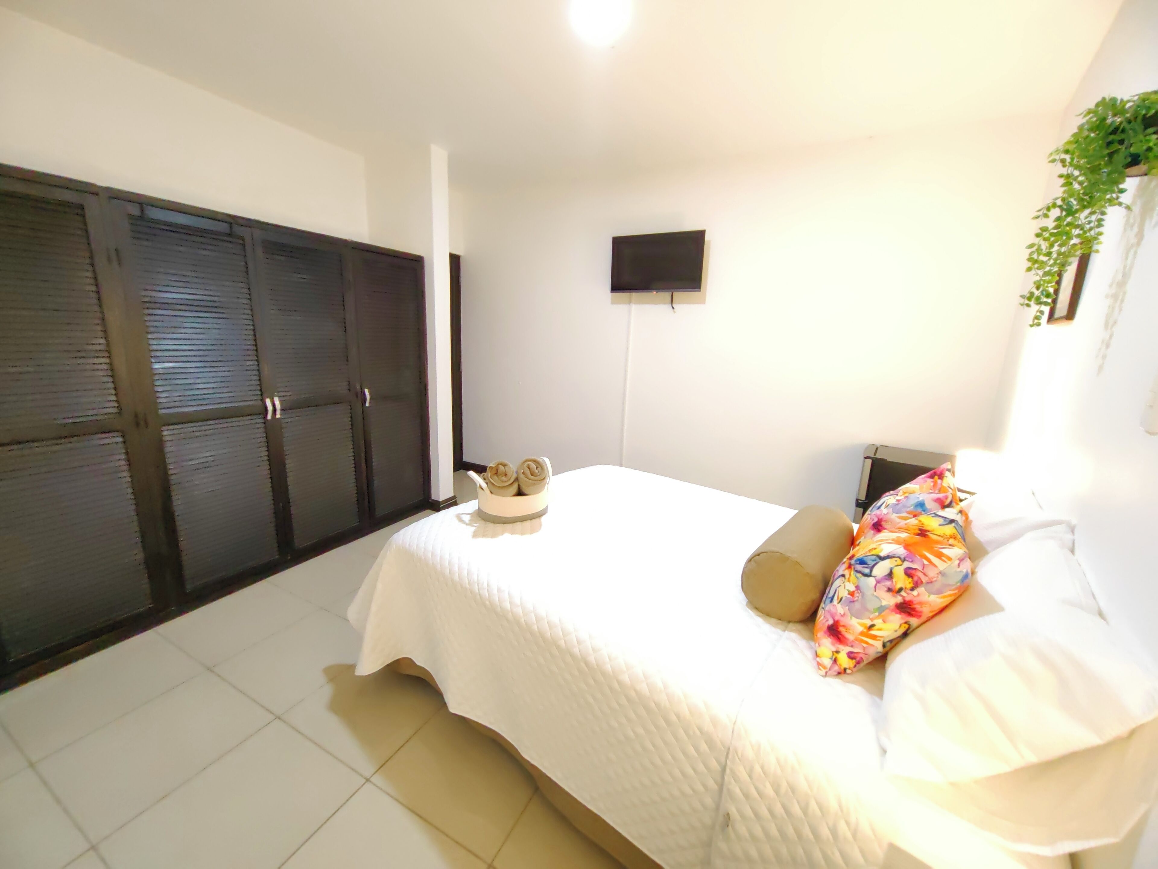 Ein Schlafzimmer mit Bett, Fernseher und Kleiderschrank.