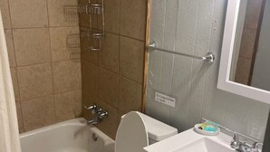 Une salle de bain avec une baignoire, des toilettes et un lavabo.