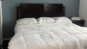 A neatly made bed with white bedding in a room with blue walls and a ceiling fan. - Charming 3-bedroom house with AC, WiFi in pleasant San Antonio (San Antonio)