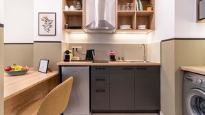 A compact kitchen with a dishwasher, a coffee maker, and a washing machine. - Mar25 #31 by Smart Cozy Suites (Athina)