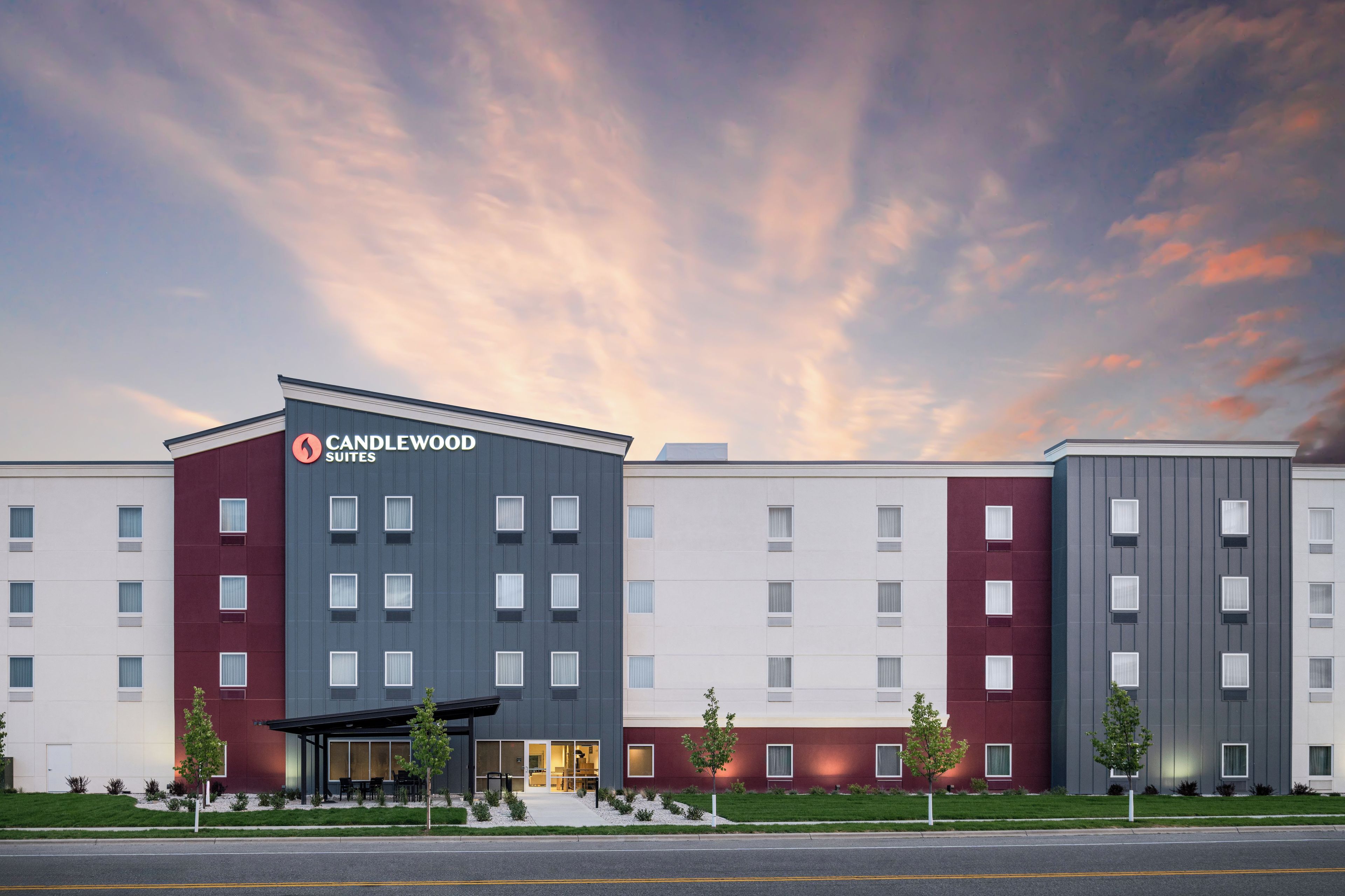 A hotel with a modern design, featuring a prominent 'CANDLEWOOD SUITES' sign.