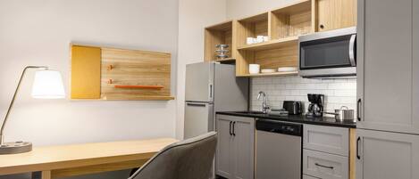 A modern kitchen with grey cabinets, a microwave, a coffee maker, and a dishwasher.